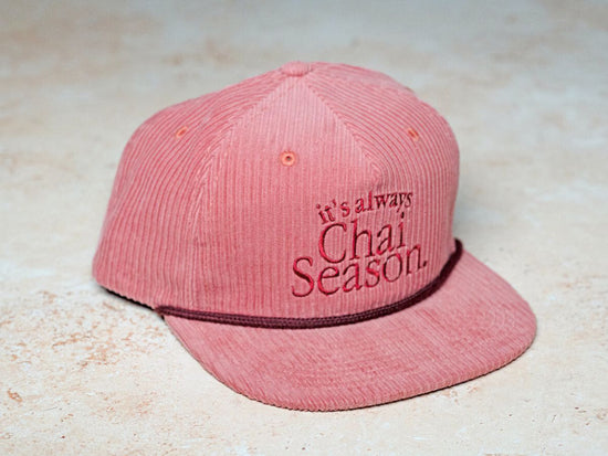 pink corduroy hat that says "its always chai season"