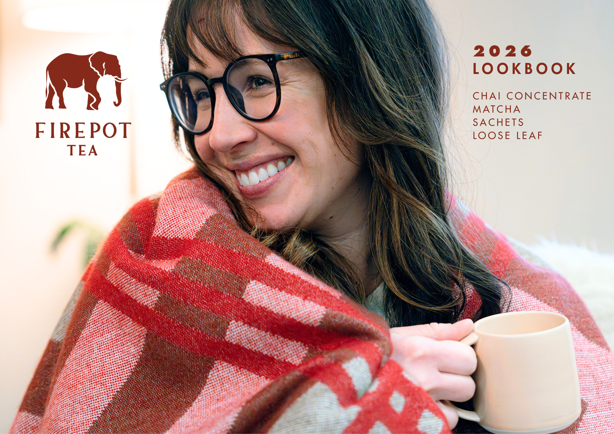 Cover of 2026 Lookbook. Woman wrapped in a red blanket holding a mug with Firepot Tea branding.