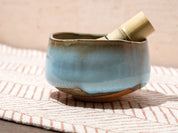 Ceramic bowl with a bamboo whisk on a textured surface