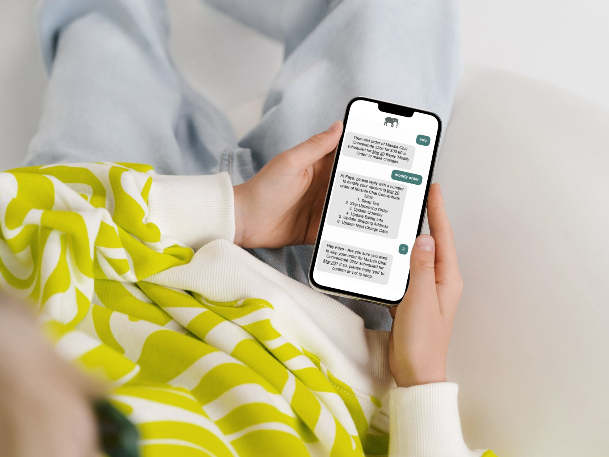 Person holding a smartphone with a text message on a light-colored surface