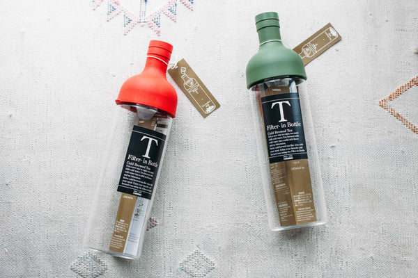 red and green Hario Filter-in Bottle Cold Brewed Tea bottles on a white Moroccan blanket